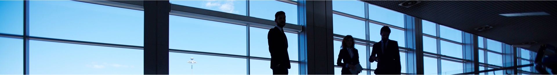 three_people_standing_at_wide_window.jpg